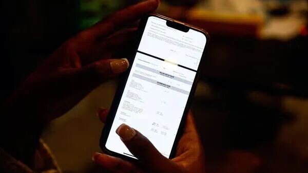 May be an image of phone and text
