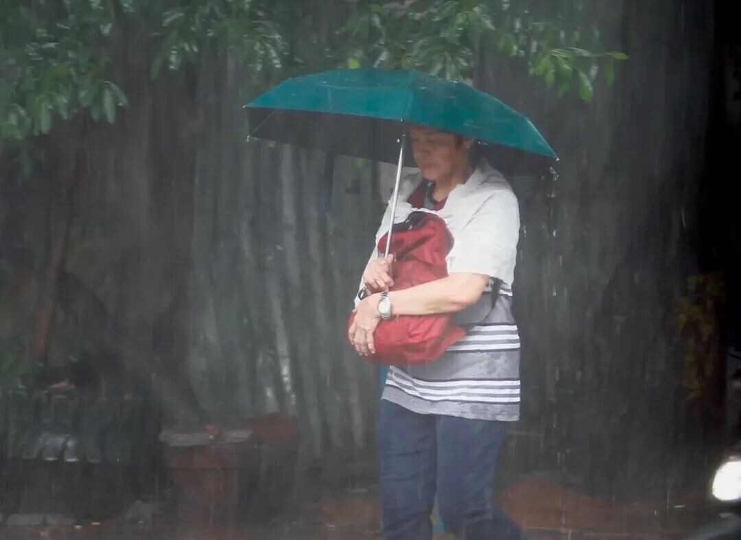 Motorists, cyclists, and pedestrians move through heavy rain in Manila on July 4, 2026, as a sudden downpour drenches parts of the capital, with intermittent monsoon rains persisting. PAGASA is also monitoring a typhoon outside the Philippine Area of Responsibility that may enhance the southwest monsoon in the coming days. (Photo taken by Mark Balmores/MANILA BULLETIN)